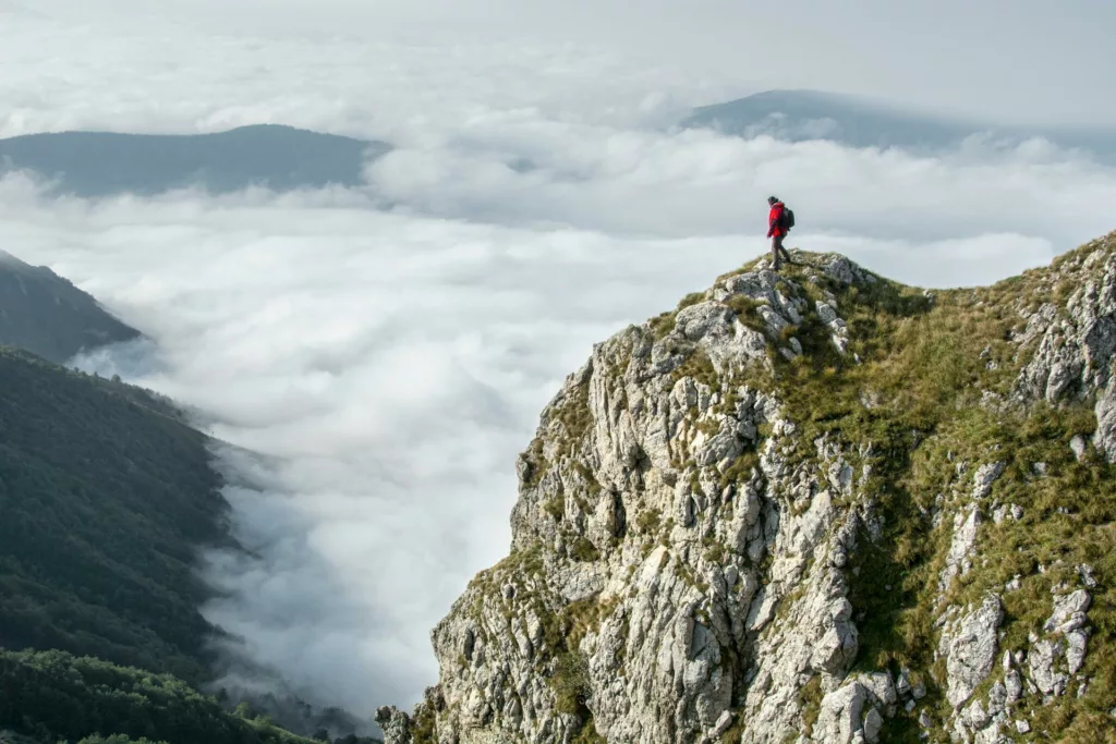 Person on a mountain Photography of Person on Green Mountain